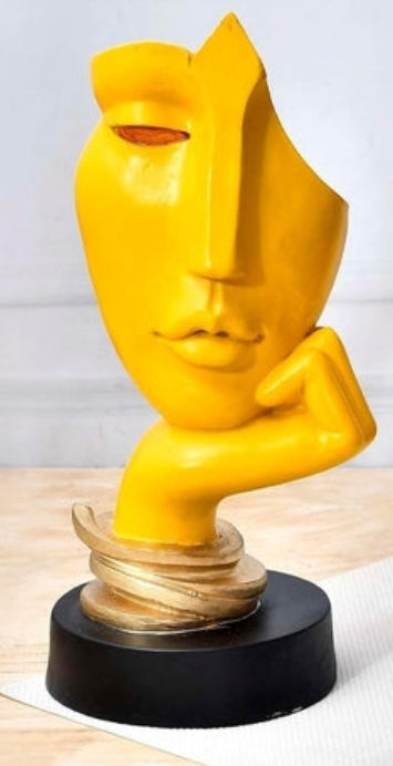 Escultura abstracta moderna de rostro amarillo sobre base dorada