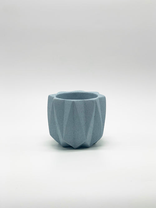 Jardinera artesanal de hormigón de geometría plegada